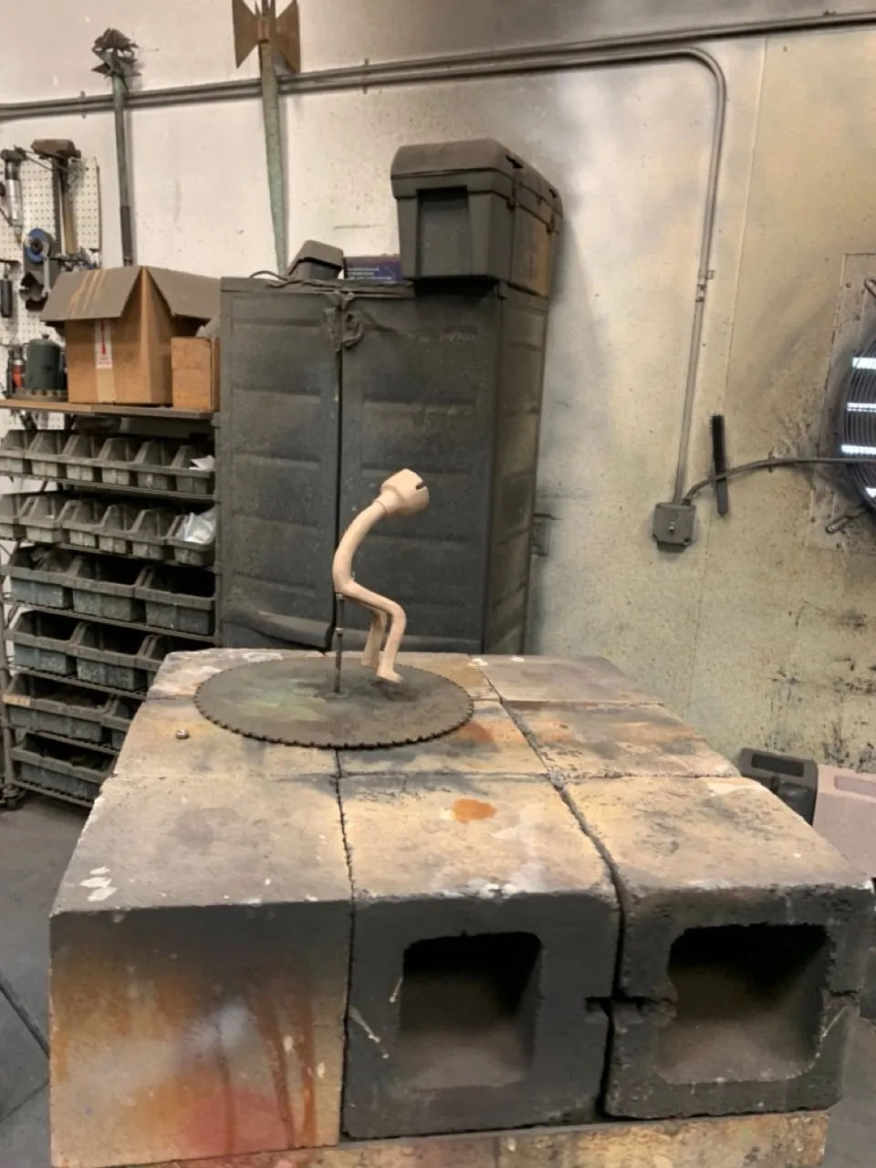 A small bronze on a steel disc, set on firebricks under the hood